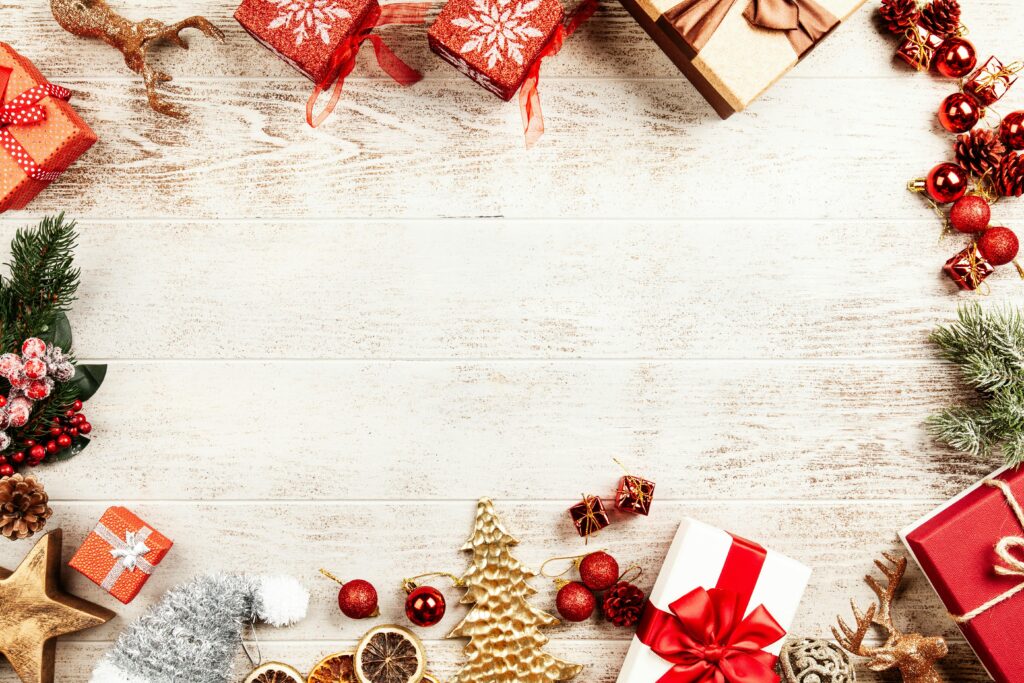 Flat lay of Christmas presents and decorations on wooden background.